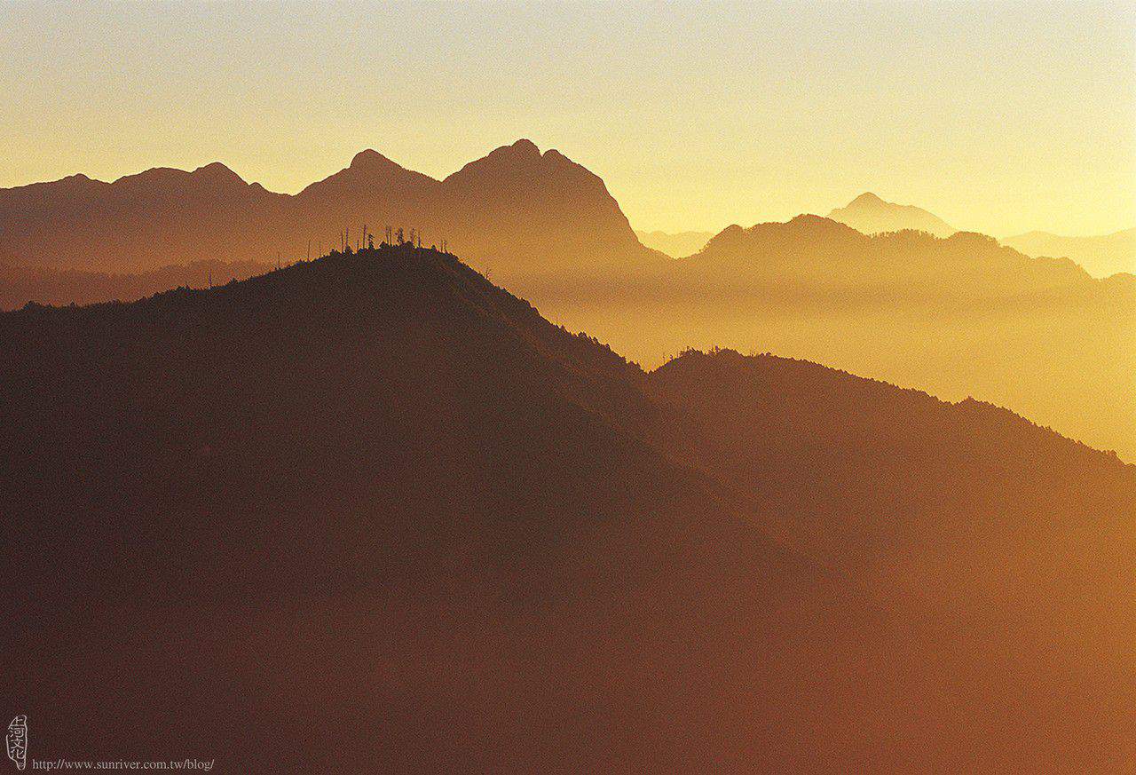 深秋的朝陽，將瀰漫在小劍山尾稜上的薄霧， 映照出金黃色的暈彩，配合著大山凹凸的剪影， 呈現出一幅空靈幻化的絕妙景致。 攝影／多陽　地點／大雪山森林遊樂區